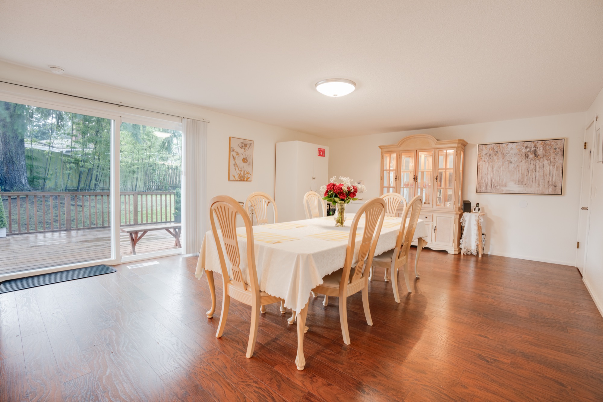 Dining area with large windows looking out to leafy backyard trees